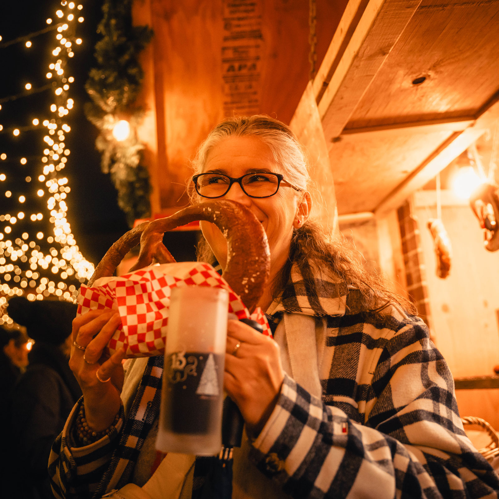 A person sniffing a german pretzel at the christmas market